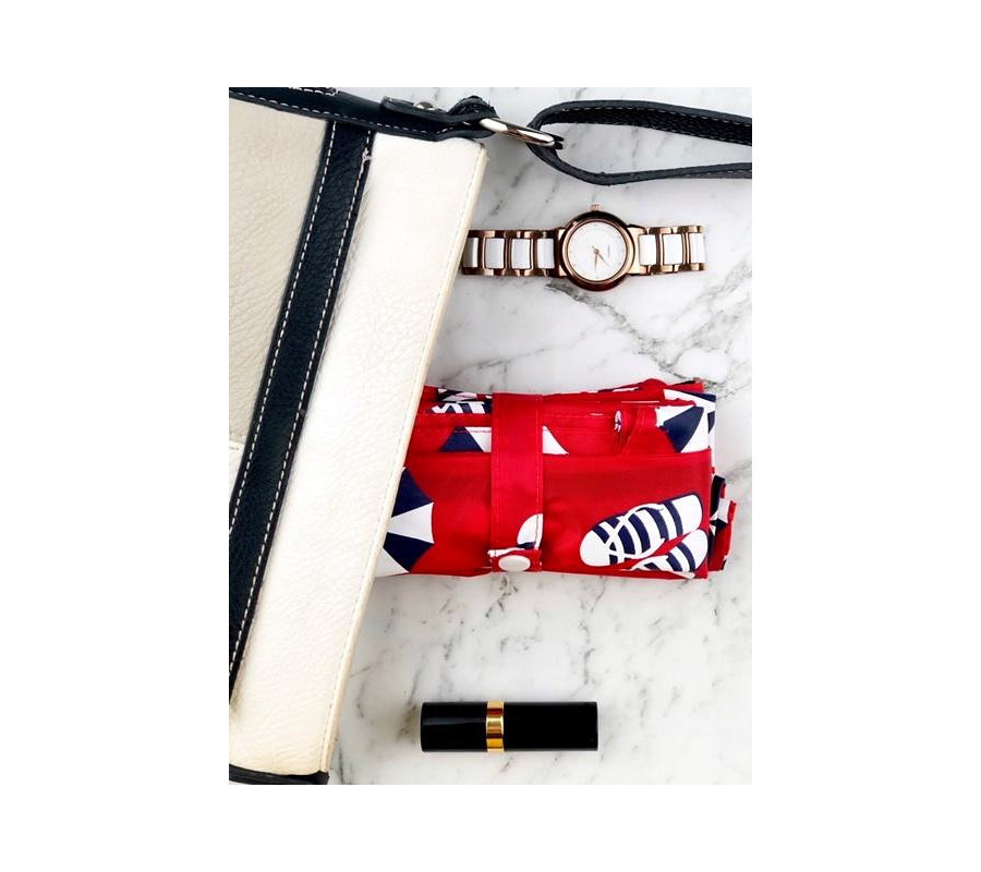 Beach print foldable bag displayed with handbag