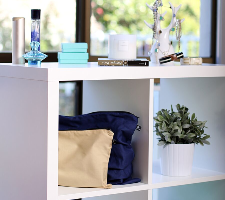 Dark blue and beige handbag dust cover bags displayed on shelf