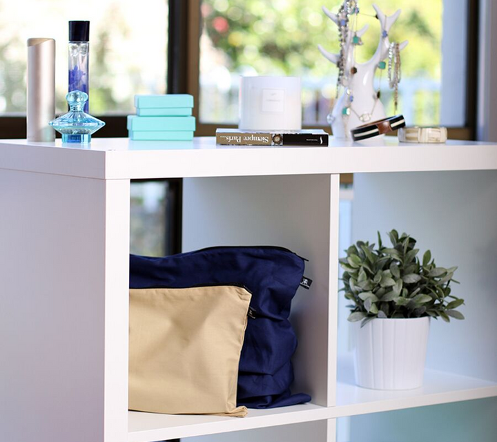 Dark blue and beige handbag dust cover bags displayed on shelf