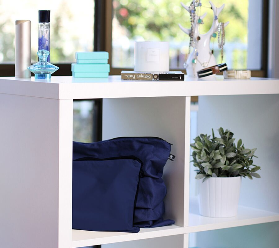 Dark blue handbag dust bags displayed on shelf