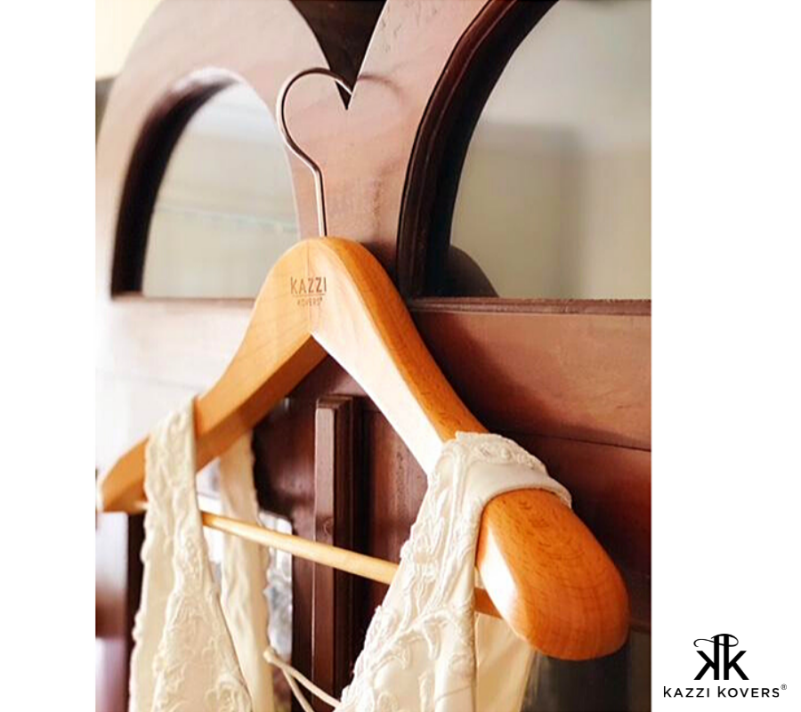 Wedding dress hanging effortlessly on a wooden hanger