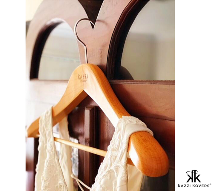 Wedding dress hanging effortlessly on a wooden hanger