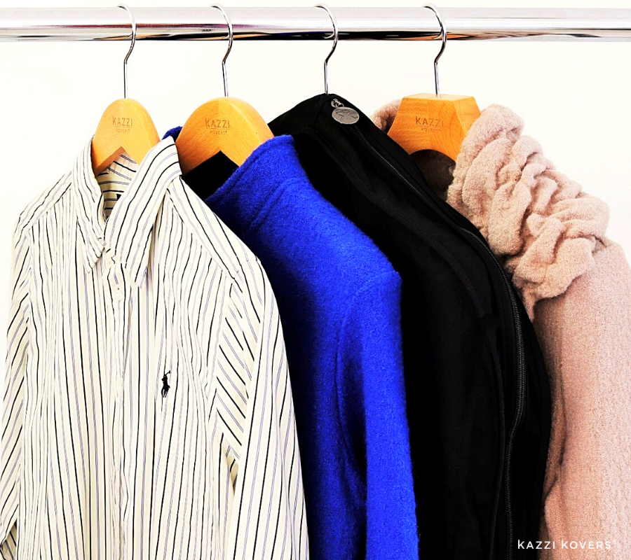 Fully enclosed black garment bag neatly organised with other garments on rack