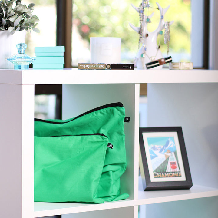 Green handbag dust bags displayed on shelf