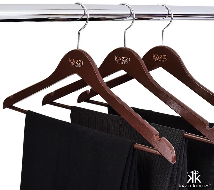 Black pants neatly hanging on dark wood hangers | Kazzi Kovers