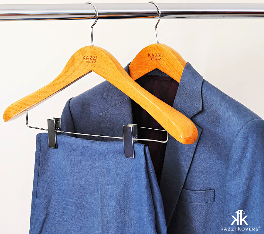 Blue suit with pants hanging nicely on wooden hanger with strong metal clips